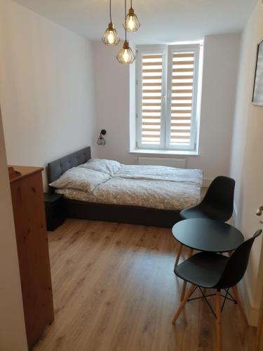 凯尔采Kobi的一间卧室配有一张床、两把椅子和一张桌子