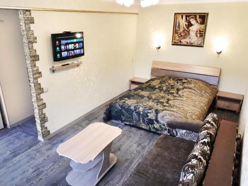 乌斯季卡缅诺戈尔斯克Lux Apartment on Mayakovsky 6的酒店客房配有一张床铺和一张桌子。