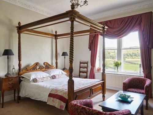 格拉辛顿坦南特阿姆斯酒店的一间卧室配有一张天蓬床和两把椅子