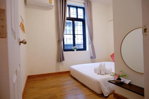 曼谷Lisa'House的一间卧室配有一张带镜子的床和窗户