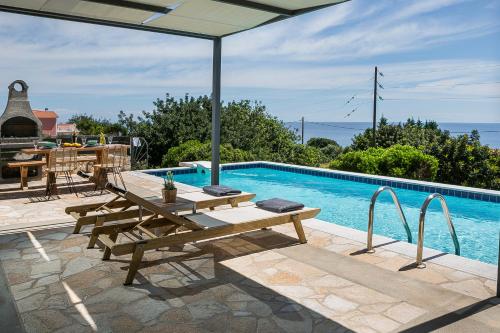 斯帕通Villa Sea front的一个带野餐桌和遮阳伞的游泳池