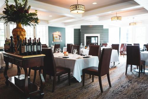 曼切斯特瑞拉豹餐厅酒店的用餐室配有带瓶装葡萄酒的桌子