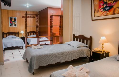 特鲁希略Hotel Amoretto的酒店客房,设有两张床和镜子