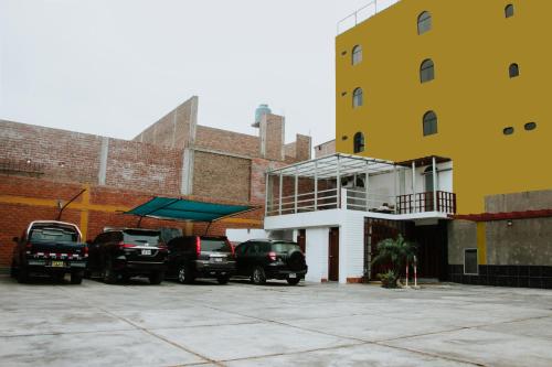 特鲁希略Hotel Amoretto的停在大楼旁边的停车场的一群汽车
