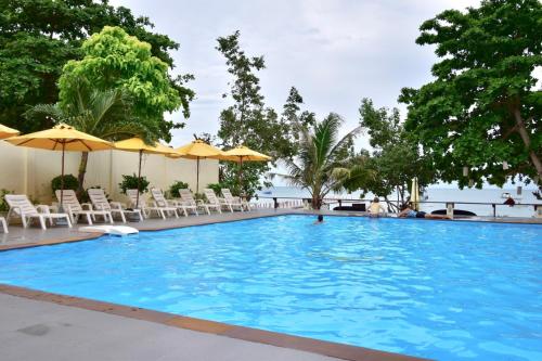 沙美岛旺德安度假村的一个带椅子和遮阳伞的大型蓝色游泳池