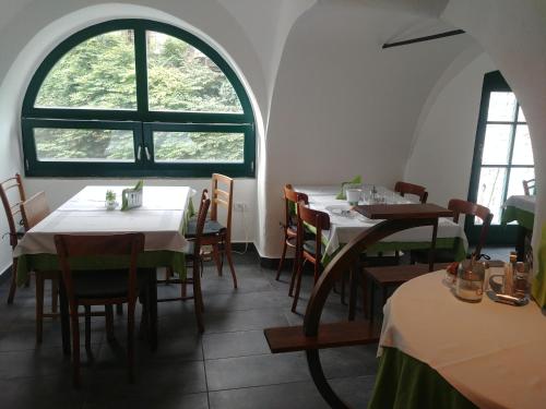什科菲亚洛卡Hotel garni Paleta的一间带桌椅的用餐室和窗户。