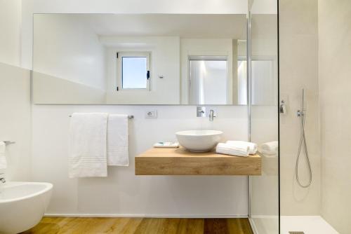 圣特奥多罗昂达玛莉娜酒店的一间带水槽和玻璃淋浴的浴室