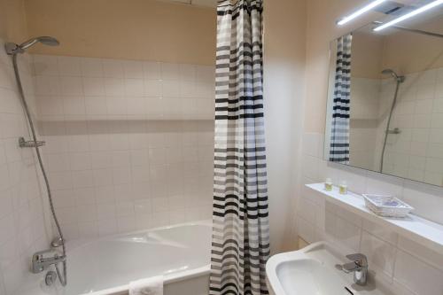 欧松讷柯尔柏酒店的带浴缸、卫生间和盥洗盆的浴室