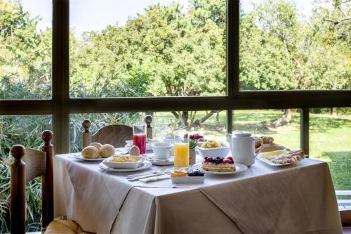 圣特奥多罗昂达玛莉娜酒店的窗户前的桌子上摆着早餐食品