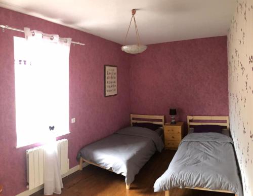 FaucompierreLE REVE DE CHARLES的紫色墙壁客房的两张床