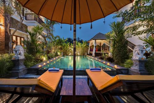 乌布Cenik Villa Ubud的一个带遮阳伞的游泳池以及度假村