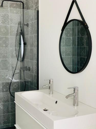 尼乌波特Zitoun的浴室配有盥洗盆和带镜子的淋浴
