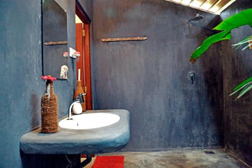 米瑞莎Chez Podi Surf Stay的一间带水槽和蓝色墙壁的浴室