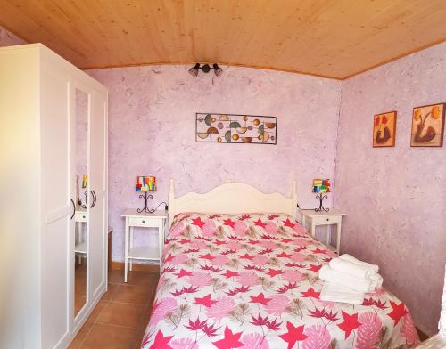 阿拉尔孔Casa Eloísa的一间卧室配有一张粉红色墙壁的床