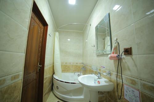 希瓦Rasulboy Guest House的一间带水槽、卫生间和镜子的浴室