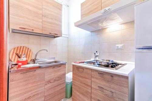 诺沃利Le Dimore di Palma的一个带木制橱柜和水槽的小厨房