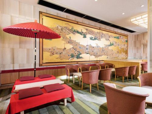京都京都新阪急酒店的餐厅设有桌椅,墙上挂着一幅大画