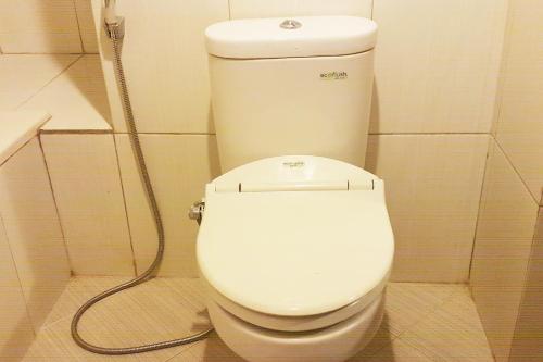沙马林达Super OYO 1088 Hotel Mega Sentosa的浴室内设有一个白色的卫生间,配有软管