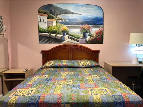 格伦代尔洛杉矶好莱坞地区格里菲斯公园汽车旅馆的卧室配有一张床,墙上挂有绘画作品