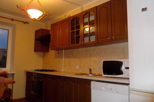 罗夫诺Comfortable apartments in centre with 3 bedrooms的一间带木制橱柜和微波炉的厨房