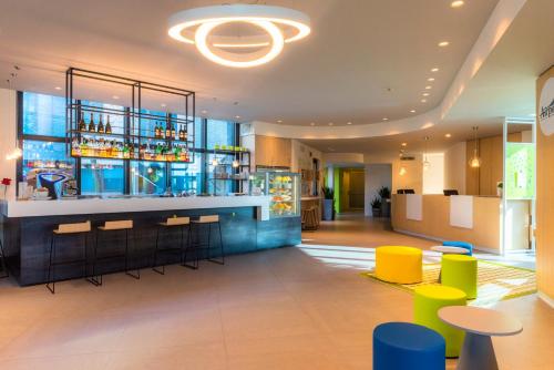巴格那提卡贝加莫机场酒店的酒店大堂的酒吧,设有色彩缤纷的凳子