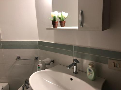 蒙德罗Great Sicily的浴室设有水槽、镜子和鲜花