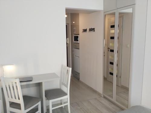 吉日茨科Apartament UnoPuro w centrum Giżycka的一间配备有白色桌子和两把椅子的用餐室