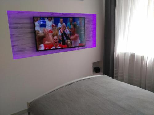吉日茨科Apartament UnoPuro w centrum Giżycka的挂在床上方的墙上的电视