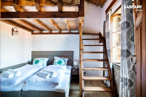 RepanídhionStone House Limnos的一间卧室配有一张双层床和梯子