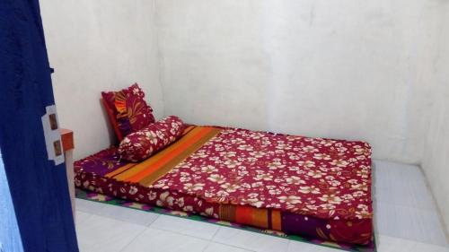 SapitMudung Keramat Homestay的白色客房内的小床,配有红色床单