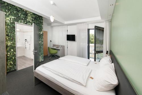 美因茨独立酒店 的卧室配有白色的床和绿色的墙壁