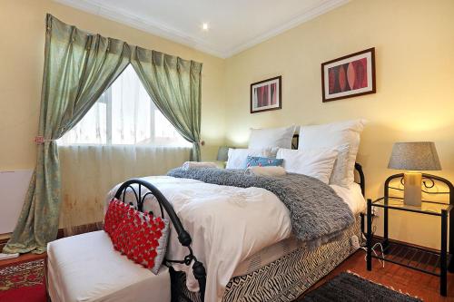 布鲁堡史特兰Natalie Guesthouse的一间卧室设有一张大床和一个窗户。