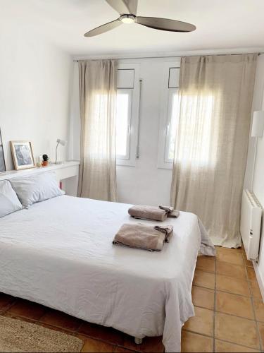 卡达克斯Apartment Boutique Hort的卧室配有白色床和毛巾