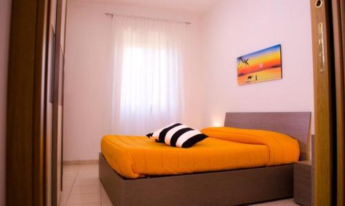 苏特里Butterfly casa vacanze的一间卧室配有橙色床和枕头