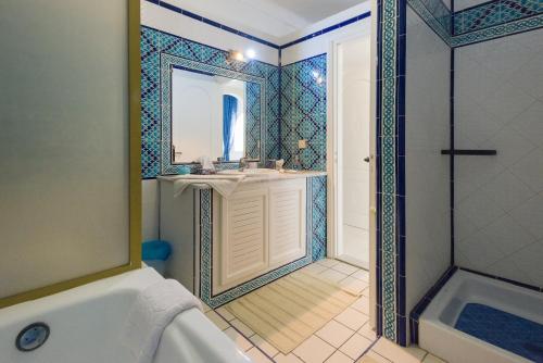 哈马马特腓尼基别墅酒店的带浴缸、水槽和镜子的浴室