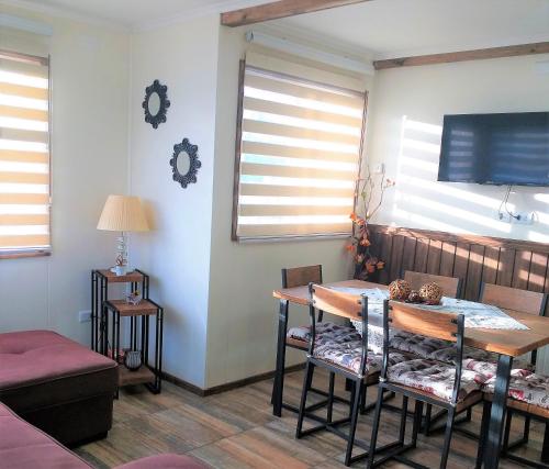 纳塔列斯港Cabañas Cerro Zapata的一间带桌椅和窗户的用餐室