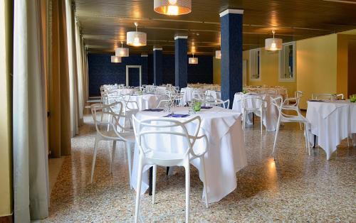 圣彼得罗-泰尔梅堡Hotel Terme di Castel San Pietro的一间设有白色桌椅的用餐室