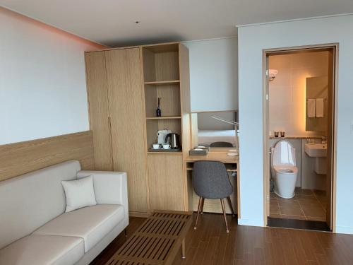 济州市Lemain Hotel的一间带白色沙发的客厅和一间浴室