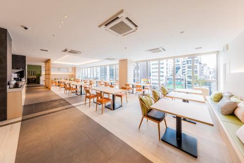 大阪Via Inn Prime Shinsaibashi Yotsubashi的一间设有桌椅和窗户的自助餐厅