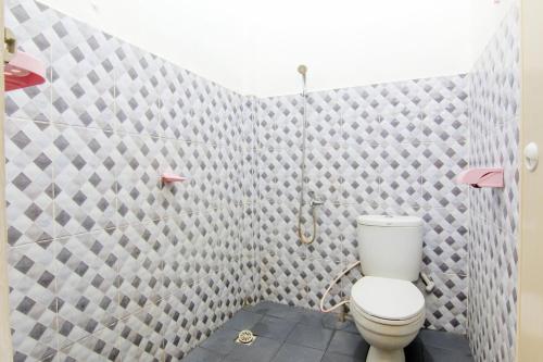SungairampahTrans Bandara Residence的一间带卫生间和瓷砖墙的浴室