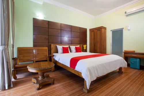 泗水RedDoorz near Juanda International Airport的一间卧室配有一张带红色枕头的大床