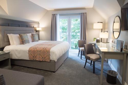 庞特普里德雷奇温大厅酒店的酒店客房带一张床、一张书桌和一面镜子