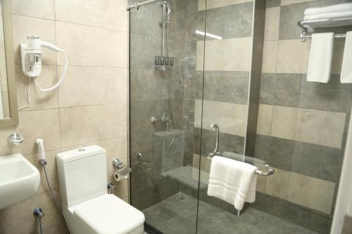 富查伊拉Uptown Hotel Apartment Fujairah By Gewan的带淋浴、卫生间和盥洗盆的浴室