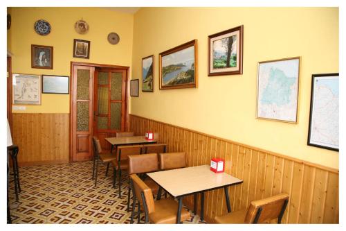 里瓦德奥Hostal Galicia的一间设有两张桌子和椅子的用餐室,墙上设有一扇墙
