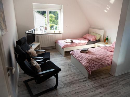 汉诺威Damm Apartments的一间小卧室,配有两张床和椅子