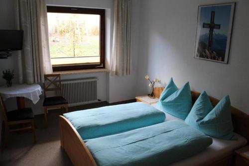 维辛Lamplhof B&B的一间卧室配有一张带蓝色枕头的床和一扇窗户。