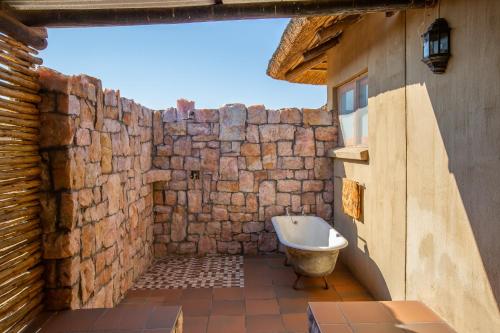 AugrabiesDaberas Guest Farm的一间带石墙和浴缸的浴室