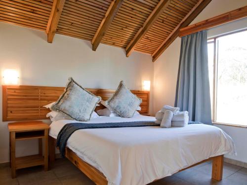 GlendaleSilverstreams Lodge and Cottage的一间卧室配有一张带白色床单的床和一扇窗户。