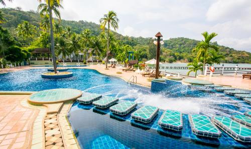 班佩罗勇度假酒店的一个带椅子和棕榈树的度假村游泳池