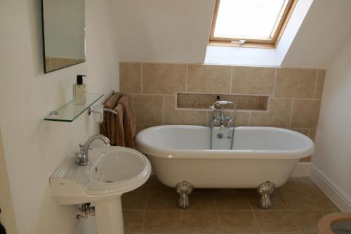 亨格福德Thatched Cottage的带浴缸和盥洗盆的浴室